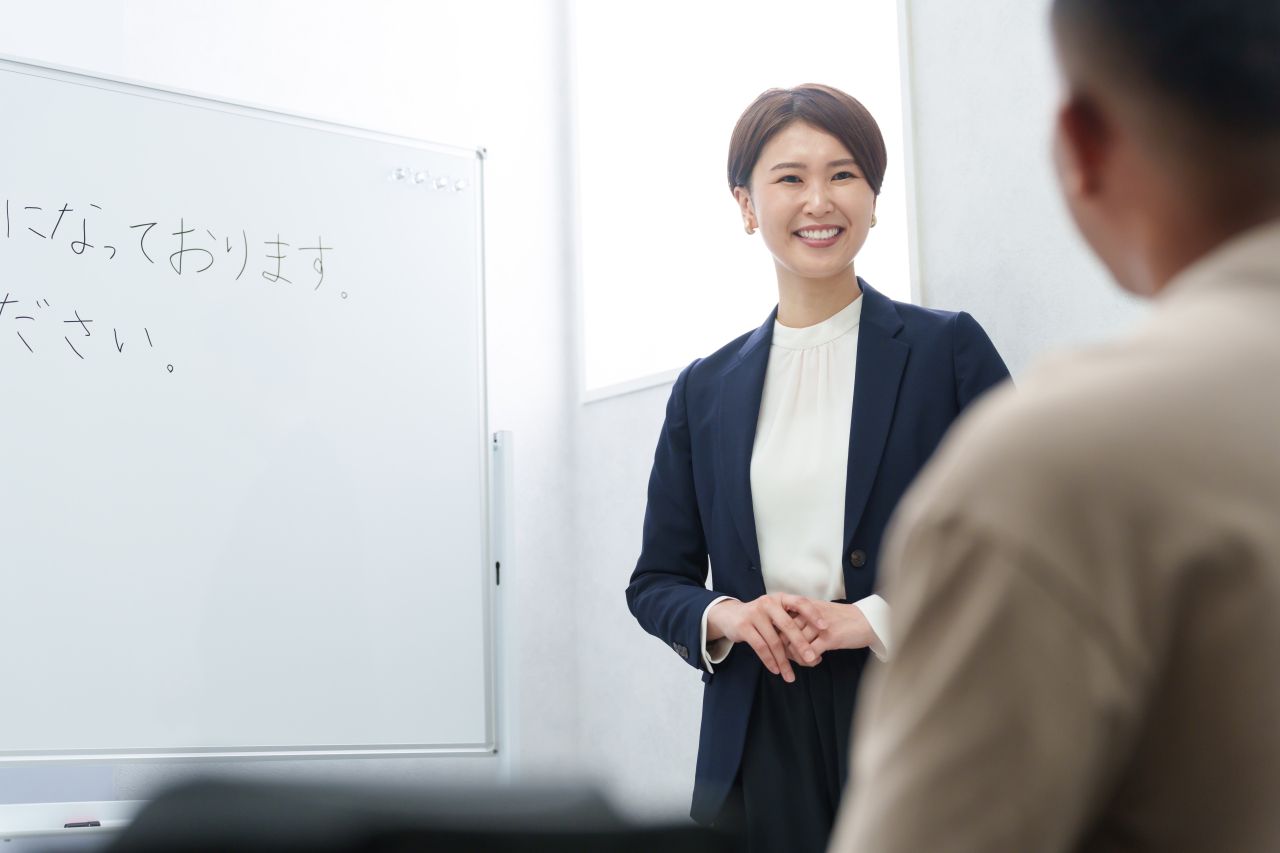 ホワイトボードのある部屋で講師から日本語講習・面談を受ける様子